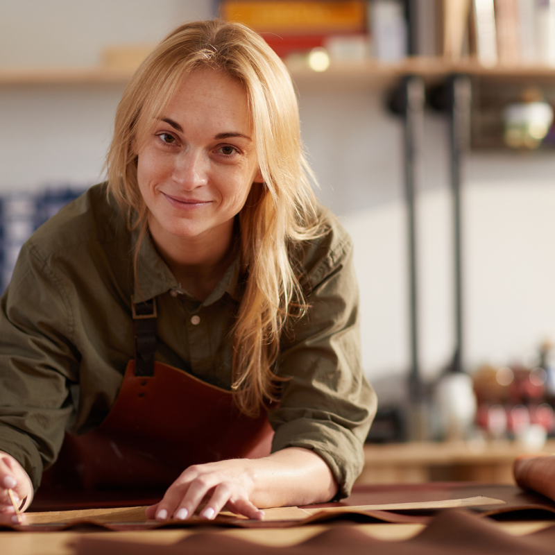 Woman leaning over desk with working with Italian leather